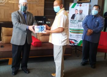 MOHD Amar Nik Abdullah menyerahkan sumbangan tablet kepada salah seorang penerima di Kota Bharu hari ini. - UTUSAN/ZULHANIFA SIDEK