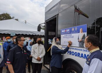 NOLEE Ashilin Mohamed Radzi  menandatangani plak perasmian Program MOVAC di Kampung Changkat Tin dekat Kampar hari ini. - UTUSAN/MOHAMAD HAFIZI MOHD. SAID.