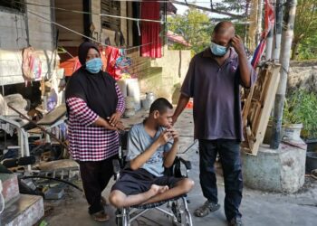 ROSLI  Sabar dan isterinya, Roszalinar Mohd. Salleh bersama anak mereka yang OKU, Muhammad Haikal di rumah sewa mereka di Teluk Intan baru-baru ini. - UTUSAN/AIN SAFRE BIDIN