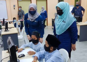 RINA Mohd. Harun melihat aktiviti yang dijalankan oleh dua kanak-kanak yang tinggal RKK Pokok Sena, Alor Setar hari ini. - UTUSAN/ZAID MOHD. NOOR