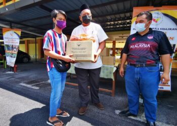 KHAIRUL Nizam Khairuddin (kanan) menyerahkan sumbangan kepada Adli pada Program Penyampaiam Sumbangan Kepada Pelajar B40 di SMK Mambau, Seremban, hari ini.-UTUSAN/AFIFI HAFIZ MOHD. NOR