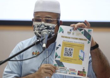 ROZALI Mohamud menunjukkan Kod QR untuk Program Vaksinasi Peniaga Pasar Awam Bukit Mertajam dan Pasar Awam Sri Rambai yang akan dijalankan secara dua fasa di Pejabat Daerah dan Tanah SPT, Pulau Pinang bermula Sabtu ini.
