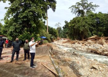 TENGKU Sarafudin Badlishah Sultan Sallehuddin merakam gambar kesan akibat tragedi kepala air ketika melawat pusat peranginan air terjun Titi Hayun, Yan. - UTUSAN/NUR SYAZWANA MANSOR