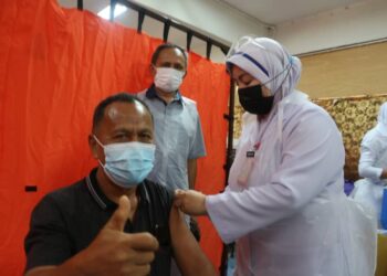 RAZAK Daud (berdiri belakang) meninjau program imunisasi kelompok dos kedua vaksin Covid-19 di Sekolah Kebangsaan (LKTP) Felda Jengka 24 di Jerantut, Pahang. - UTUSAN/SALEHUDIN MAT RASAD