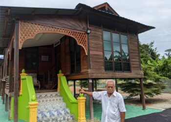 HASHIM Abd. Rahman menjaga rumah pusaka datuk kepada Muhaini Zainal Abidin  di Kampung Pulau Tiga Kiri, Kampung Gajah. - UTUSAN/MOHAMAD HAFIZI MOHD. SAID