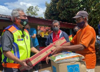 MOHD. Redzuan Yusof (kiri) menyampaikan sumbangan kepada salah seorang penduduk yang terjejas dalam tragedi kepala air di Kampung Permatang Keramat, Yan. - UTUSAN/MOHD. RAFIE AZIMI