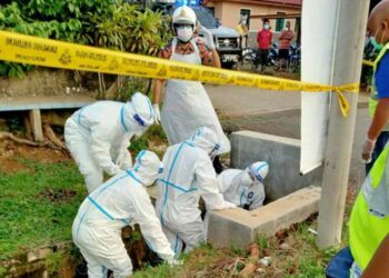 PASUKAN bomba mengeluarkan mayat seorang lelaki yang dipercayai maut akibat terjatuh dalam pembetung longkang dalam kejadian di Bukit Lintang, Kandang, Melaka. - UTUSAN/DIYANATUL ATIQAH ZAKARYA