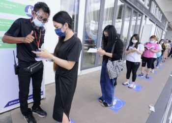 SEORANG petugas PPV Pikas di D’Cattleya, Senawang, Seremban membantu pekerja industri yang hadir ke PPV berkenaan untuk menerima vaksin Covid-19 masing-masing, baru-baru ini.UTUSAN/MOHD. SHAHJEHAN MAAMIN