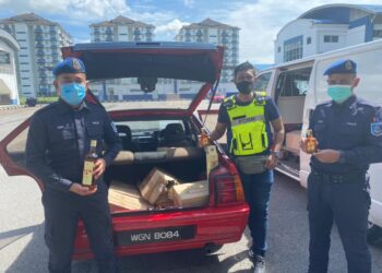 ANGGOTA PPM Pelabuhan Klang menujukkan arak dan kenderaan yang dirampas dalam serbuan di kawasan parkir Flat PKNS, Shah Alam, Selangor, semalam.