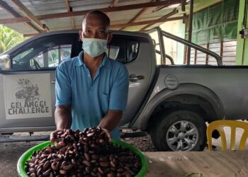 MOHD. Simin Abdullah menunjukkan biji perah siap dijeruk sebelum dibungkus untuk dijual kepada pelanggan di Felda Kota Gelanggi Dua di Jerantut, Pahang.  – UTUSAN/HARIS FADILAH AHMAD