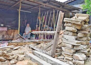 CHE Bidah Che Hassan memandang dapur rumahnya yang runtuh di Kampung Salak, Belimbing, Tanah Merah. - UTUSAN/BAHRUDDIN HATTA