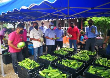 AZAHAR Ibrahim (tiga dari kiri) bersama wakil usahawan rock melon, Hamid Yahya (dua dari kiri) bergambar bersama sebahagian dua tan sayuran yang disumbang kepada golongan asnaf sekitar Kampung Perepat hari ini. - UTUSAN / ABDUL RAZAK IDRI