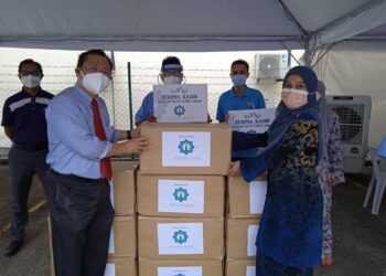 AZREEN Syazril (kiri) menyerahkan beg mayat kepada Dr. Nur Ayutimasery untuk digunakan bagi menguruskan jenazah pesakit Covid-19 di HTAR, Klang, Selangor hari ini.