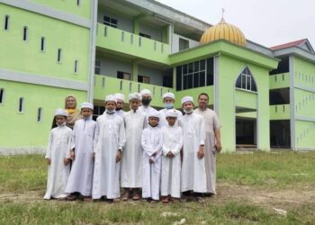 SEBAHAGIAN pelajar Maahad Tahfiz Abu Bakar di Tanah Merah, Kelantan bergambar bersama tenaga pengajar di hadapan sekolah itu sebelum Covid-19 melanda negara tahun lalu.
