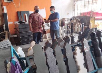 RAJA FAIZUDIN menunjukkan contoh batu nisan dan belindan yang sudah siap di kedainya di Jalan Sultanah Zainab, Kota Bharu semalam. - UTUSAN/ROHANA MOHD NAWI