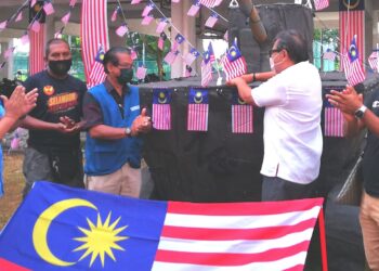 ABDUL Rashid Asari (kanan) memasang Jalur Gemilang sebagai simbolik Majlis Perasmian Program Semarak Merdeka Pangsapuri Seri Perantau hari ini. - UTUSAN/ABDUL RAZAK IDRIS