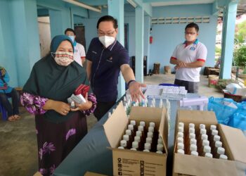 JIMMY Puah Wee Tse (dua kanan) mengagihkan 150 Kit Ujian Kendiri Covid-19 di Flat Cengal, Taman Putri Kulai, di Johor.