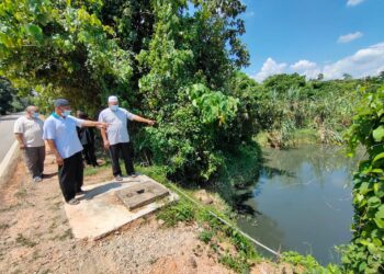 PENDUDUK kampung menunjukkan anak Sungai Air Salak yang berubah warna menjadi hitam serta berbau busuk di Kampung Batang Rokan, Gemencheh, Tampin, hari ini.-UTUSAN/NOR AINNA HAMZAH.