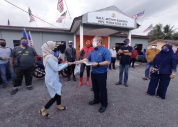 DR. Adham Baba (depan kanan) menyerahkan pelitup muka kepada penduduk Taman Kota Jaya di Balairaya Taman Kota Jaya di Kota Tinggi, Johor.