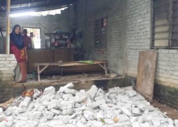 RAHMAH Ismail melihat dinding bahagian dapur rumahnya yang runtuh selepass kejadian kepala air di Kampung Batas Ubi, Yan, Kedah,  hari ini. - UTUSAN/OTHMAN YAHAYA