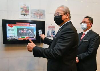 ANNUAR Musa merakam kad pengimbas waktu sebagai simbolik memulakan tugas di Kementerian Komunikasi dan Multimedia, Putrajaya. - FOTO FB ANNUAR MUSA