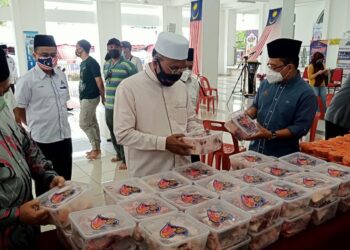 IDRIS Ahmad (tengah) melihat sumbangan daging lembu yang diberikan badan korporat untuk diserahkan kepada kariah terjejas di sekitar Putrajaya. - UTUSAN/MOHD. HUSNI MOHD NOOR