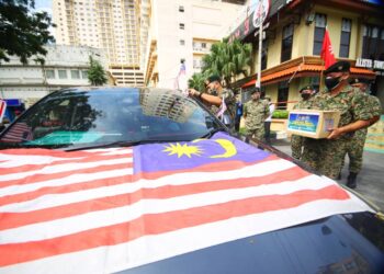 ABU Hasan Assha'ari Kamis (kiri) memasang Jalur Gemilang pada sebuah kereta wakil persatuan veteran tentera secara pandu lalu di Tambatan Di Raja, Kota Bharu hari ini. - UTUSAN/ZULHANIFA SIDEK