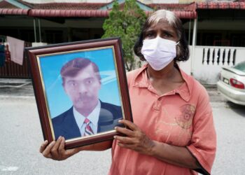 E. PHILOMENA memegang gambar suaminya, ketika ditemui pemberita di rumahnya di Taman Buntong Ria, Ipoh hari ini. - UTUSAN/ZULFACHRI ZULKIFLI
