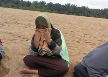 SENAH Ismail mencium baju-T milik anak bongsunya, Ahmad Firdaus Afiq Che Yusof yang dipakai semasa tiba di Sungai Dungun di Kampung Tok Kah di Dungun.- UTUSAN/NIK NUR IZZATUL HAZWANI NIK ADNAN