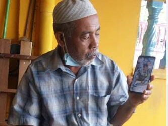 MOHAMAD Isa Osman melihat gambar anaknya, Allahyarham Mohamad Azrin di Taman Desa Aman, Sungai Lalang, Sungai Petani hari ini. - UTUSAN/OTHMAN YAHAYA