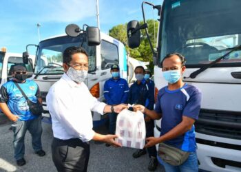 JALALUDDIN Alias beramah mesra dengan para petugas Air Selangor yang menghantar bekalan di Putrajaya Sentral, Presint 7, di sini hari ini. – Ihsan FB Jalaluddin Alias
