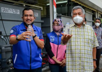 ASYRAF Wajdi Dusuki (kiri) bersama Zahida Zarik Khan (tengah) dan Ahmad Said (kiri) memegang air bersih daripada loji rawatan air bergerak di Dataran Jeram Hulu di Kuala Nerus hari ini. - PUQTRA HAIRRY ROSLI
