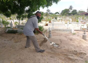 MOHD. Asri Ghani menutup kembali kubur yang dikorek kumpulan anjing liar di Tanah Perkuburan Islam Kampung Limbong, Paka di Dungun. - UTUSAN/NIK NUR IZZATUL HAZWANI NIK ADNAN