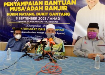 IDRIS Ahmad (tengah) pada sidang akhbar selepas menyampaikan sumbangan kepada mangsa banjir di Bukit Gantang. - UTUSAN/WAT KAMAL ABAS