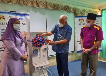 MAHDZIR Khalid (tengah) menyerahkan mesin hemodialisis kepada Hospital Kuala Nerang, Padang Terap. - UTUSAN/MOHD. RIFAAT ABD. HAMID