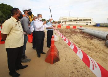 MUSTAPA Mohamed mendengar taklimat berkaitan perkembangan terkini projek menaik taraf LTSIP di Pengkalan Chepa, Kota Bharu. - UTUSAN/ZULHANIFA SIDEK