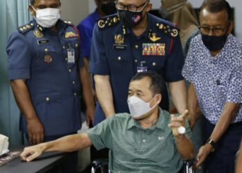 MOHAMMAD Hamdan Wahid (tengah) menolak kerusi roda dinaiki Abdullah Morad
di Jalan Putra, Alor Setar hari ini. - UTUSAN/MOHD. RAFIE AZIMI