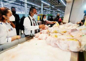 ISMAIL Othman (dua dari kiri) memeriksa harga ayam sambil disaksikan Norena Jaafar (kiri) ketika pemantauan KPDNHEP Melaka di sebuah pasar raya di Peringgit, Melaka. - UTUSAN/DIYANATUL ATIQAH ZAKARYA