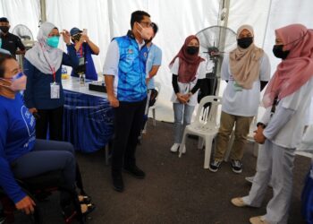 AHMAD Faizal Azumu (tiga dari kiri) beramah mesra dengan para sukarelawan Southern Volunteers Johor sambil diperhatikan oleh dan Senator Datuk Ras Adiba Radzi (kiri) ketika hadir melawat PPV Pandu Lalu OKU Sentral di Pusat Akuatik MBJB Arena Larkin disini. UTUSAN.RAJA JAAFAR ALI