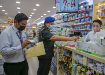 RAE Morn Verak (kiri) memeriksa harga kit ujian pantas antigen Covid-19 di sebuah farmasi di Simpang Kuala, Alor Setar hari ini. - UTUSAN/SHAHIR NOORDIN