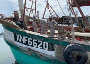 SYED Nor Adli Syed Ab. Rahman (kiri) memeriksa pukat digunakan nelayan Vietnam yang ditahan kerana mencuri hasil laut di Tok Bali, Pasir Puteh, hari ini. - UTUSAN/TOREK SULONG