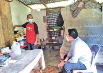 MOHD. Azman Ghazali (duduk) memerhatikan Mohd. Zakuan Ibrahim memasak di rumahnya di Kampung Pangkal Changgong, Machang. - UTUSAN/ROHANA MOHD. NAWI