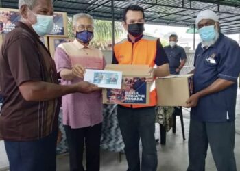 Mansor Othman (dua dari kiri) ketika menyerahkan bantuan kepada mangsa ribut yang melibatkan dua buah kampung di Nibong Tebal, baru-baru ini