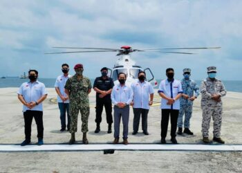 RODZI Md. Saad (tengah) bergambar dengan para pegawai kanan keselamatan di Pangkalan Maritim Abu Bakar berlatarkan Batu Puteh di belakang. – Ihsan KP MKN