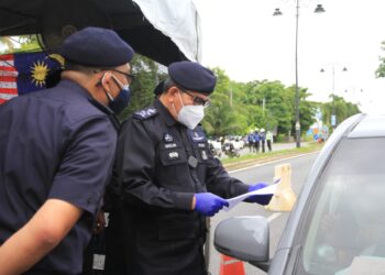 MAZLAN Lazim (kanan) memeriksa dokumen perjalanan seorang pemandu di SJR Kuala Kedah, Alor Setar hari ini. - UTUSAN/MOHD. RAFIE AZMI