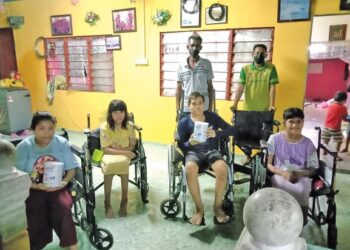 ABDUL Rahman Hashim (berdiri, kiri) bersama empat anaknya yang berstatus OKU ketika menerima sumbangan kerusi roda daripada wakil Yayasan Amal Malaysia  (berdiri, kanan) di Kampung Tersusun Kuala Gula di Bagan Serai. - UTUSAN/WAT KAMAL ABAS