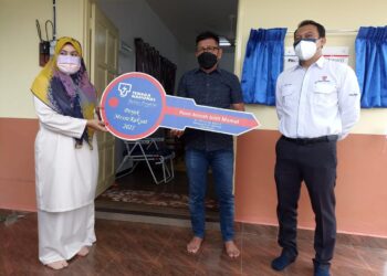 NORHIZAM Hassan Baktee (tengah) menyerahkan replika kunci rumah kepada Anisah Mamat sambil disaksikan Ahmad Fadhil Aziz di Kampung Baroh, Melaka. - UTUSAN/DIYANATUL ATIQAH ZAKARYA
