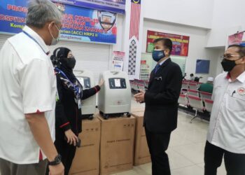 DR. ZAINI Hussin melihat oxygen concentrator yang disumbangkan Firma Guaman Afiq & Co sambil diperhatikan Pengarah HRPZ II, Datuk Dr. Selasawati Ghazali di Kota Bharu hari ini. - UTUSAN/ROSALWANI CHE SOH