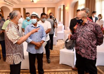 MUHYIDDIN Yassin (kiri) beramah mesra dengan peserta yang hadir pada sesi dialog bersama pengusaha hotel, homestay, kereta sewa dan pemandu teksi di Langkawi hari ini.