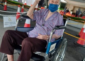 CHOONG YAT HAN menunjukkan isyarat bagus setelah disuntik vaksin Covid-19 di PPV Meru Valley Resort di Meru, Ipoh hari ini. - UTUSAN